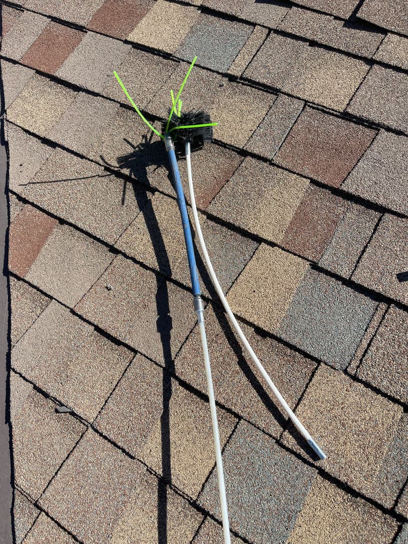 Dryer vent cleaning tools and extracted lint on flat rooftop