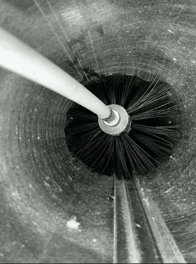 Technician with heavily lint-clogged dryer vent in laundry room